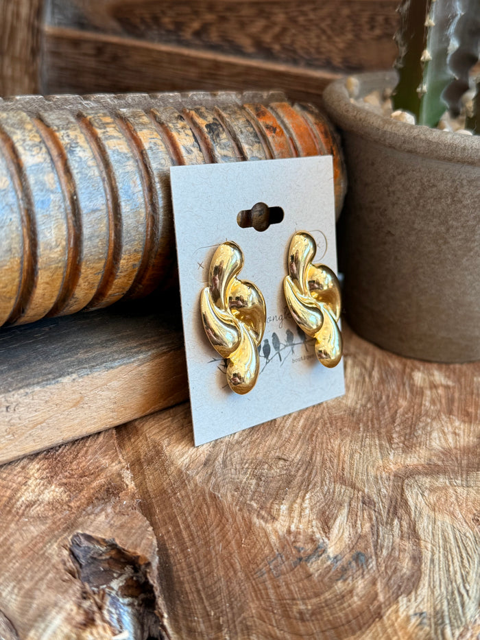 Gold-plated twisted teardrop stud earrings, angled view on white card