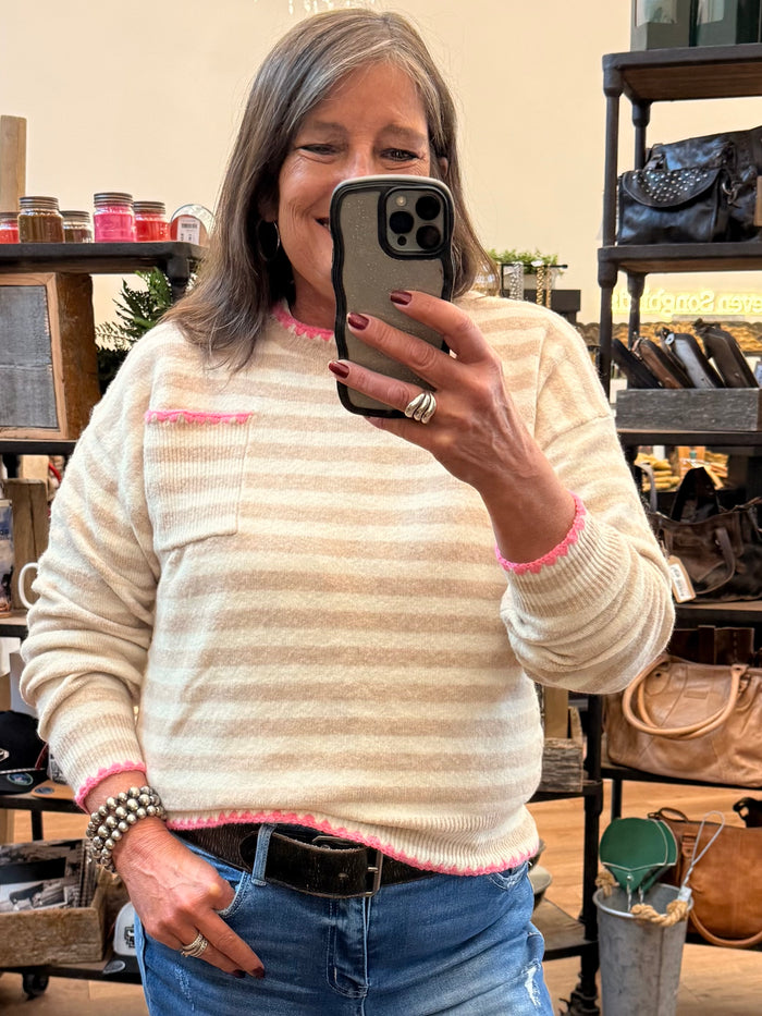 Cream crew neck sweater with pink striped knit and whip-stitched trim at cuffs and hem
