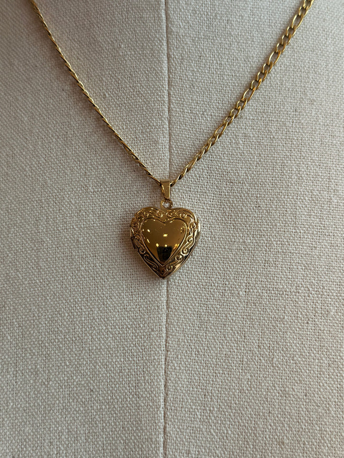 Gold-plated heart locket pendant on a thin gold chain, front close-up
