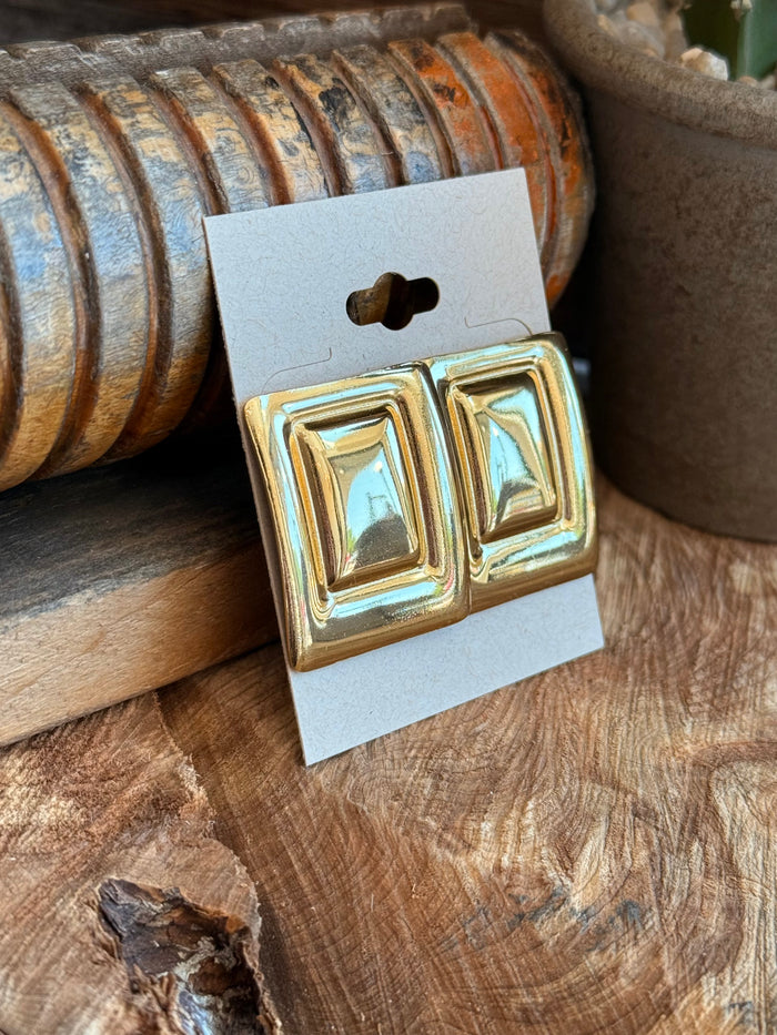 Angled gold-plated double-square stud earrings on display card