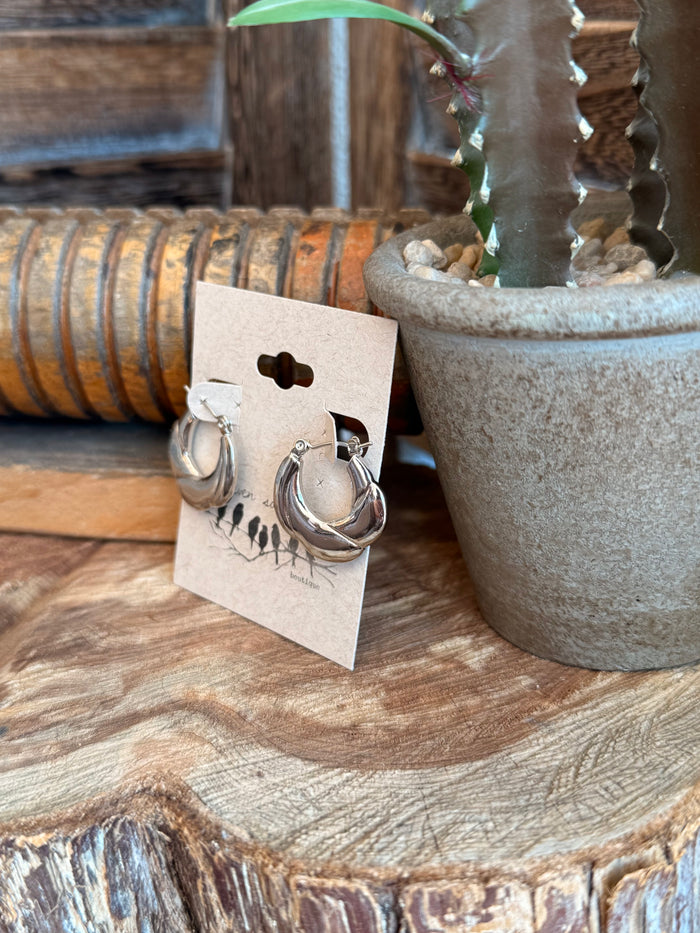 Curvy bumpy silver hoop stud earrings, side view showing textured metal hoops