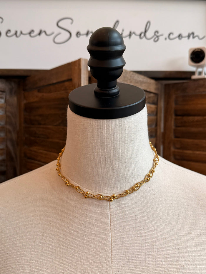 Gold-plated stainless steel chain necklace on mannequin, woven link design