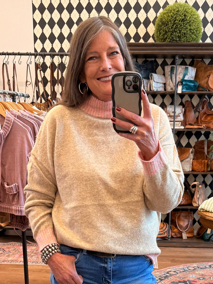 Beige and pink striped mockneck sweater, long sleeves, relaxed fit.