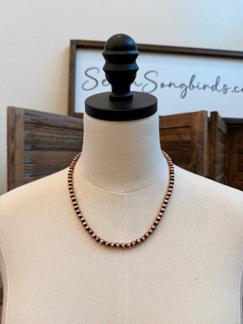 Genuine copper bead necklace on a mannequin, short rounded bead strand