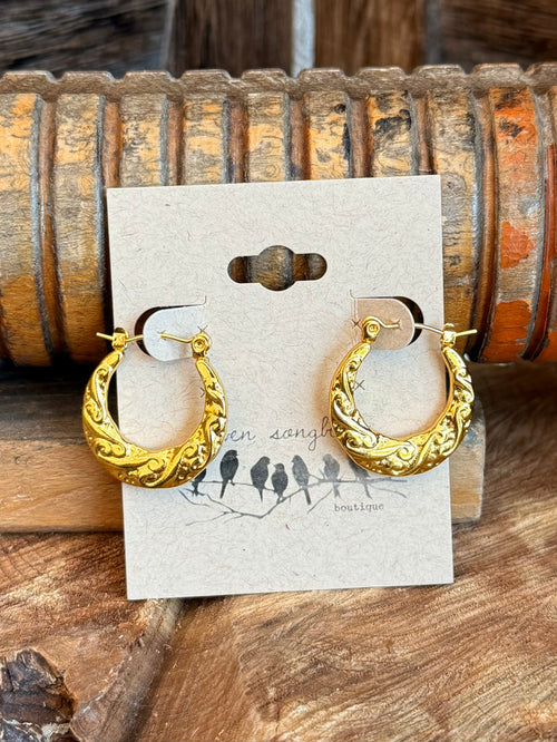 Gold-tone textured half hoop earrings on a display card