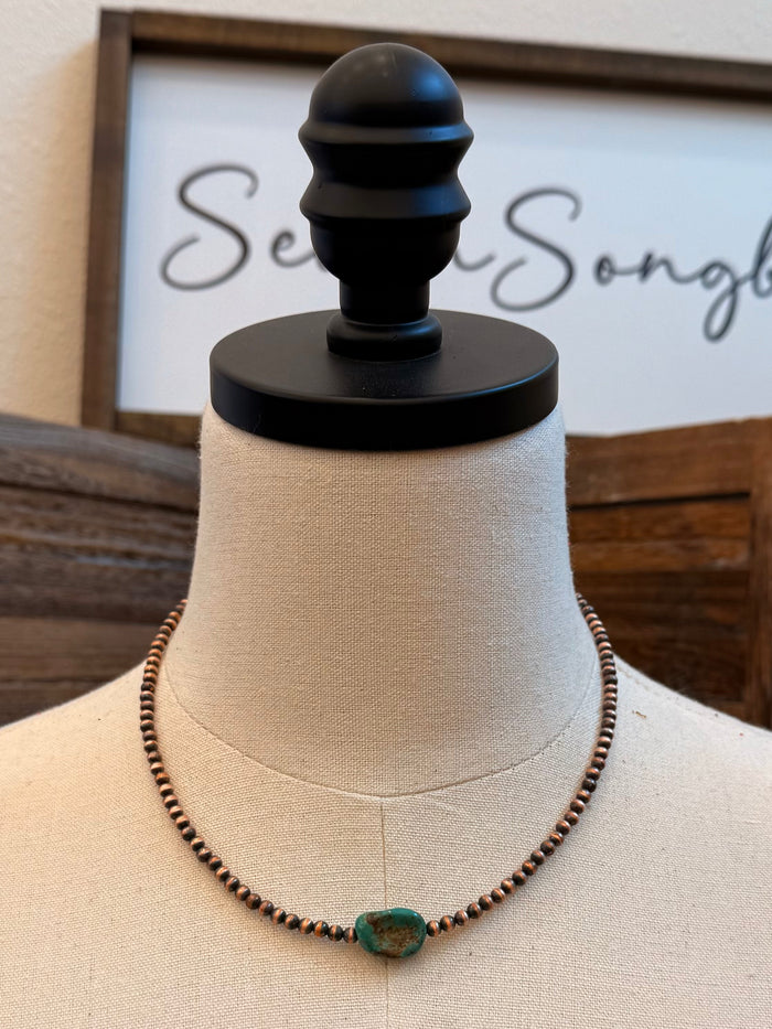 Turquoise copper beaded necklace with oval turquoise stone, front view on mannequin