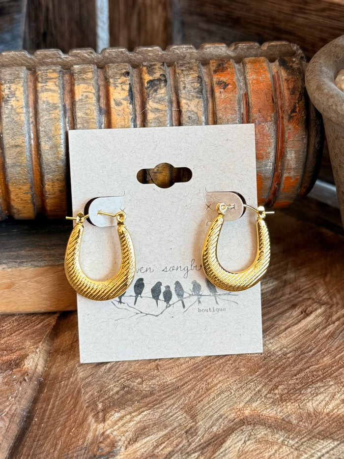Gold-tone textured half-hoop earrings with rounded hoop profile and clasp backs
