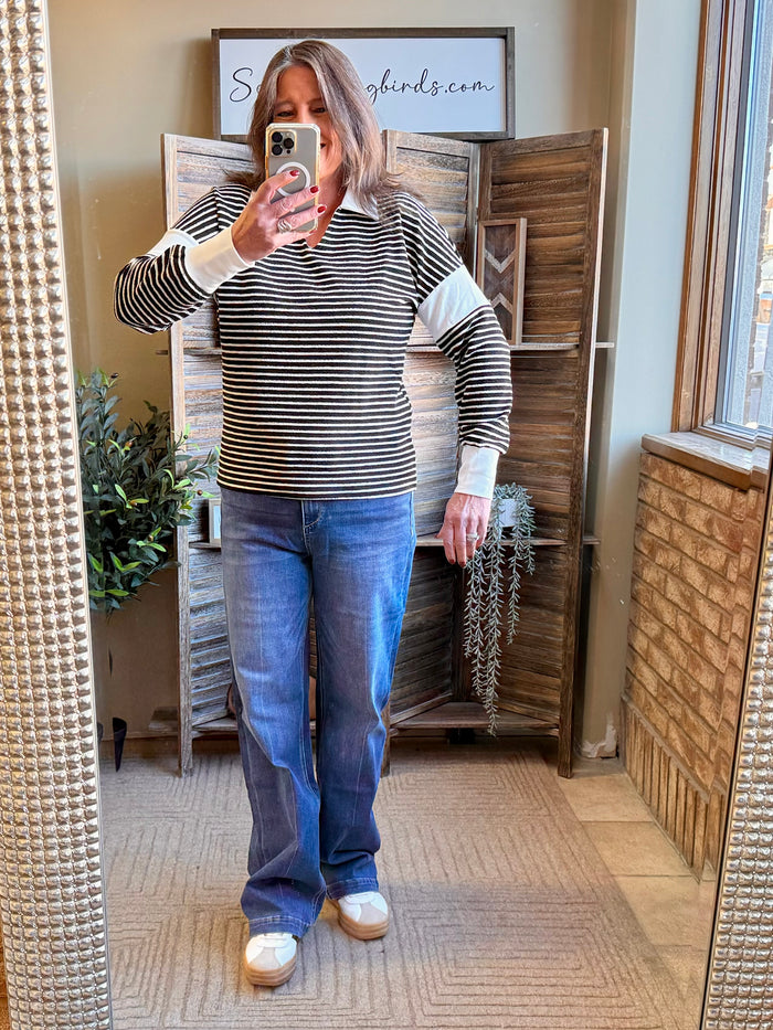 Black and white striped long-sleeve polo shirt with ribbed collar and light cuffs
