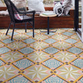 Patterned floor tiles in a geometric design with a chair and table in the background.