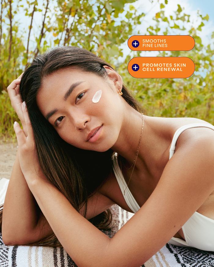 Young woman with smooth skin outdoors applying Dream Bio-Retinol + Shorea Butter Rejuvenating Cream | Three Ships, highlighting skincare benefits like smoothing fine lines and promoting skin cell renewal.