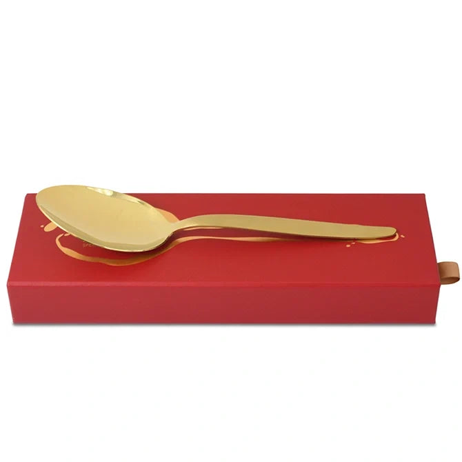 Gray Kunz Spoon Limited Edition in Gold on top of red box on white background.
