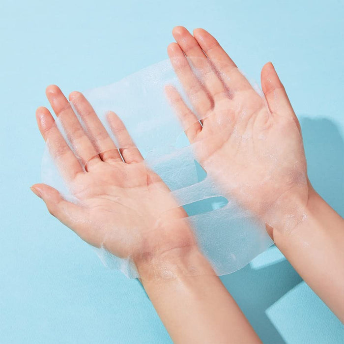Hands holding a translucent skincare sheet mask on a light blue background, representing a wellness supplement product named ImPHYTO Collagen | Leaders.