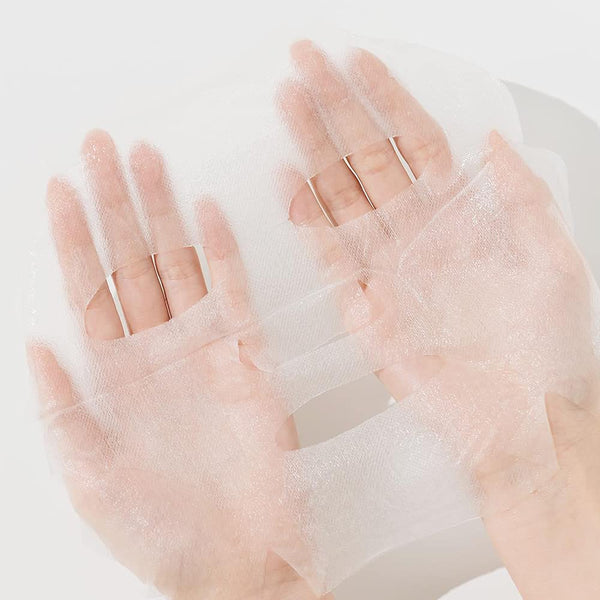 Hands holding a delicate, transparent sheet mask representing the soothing skincare effects of ImPHYTO Vitamin | Leaders for wellness and body care.