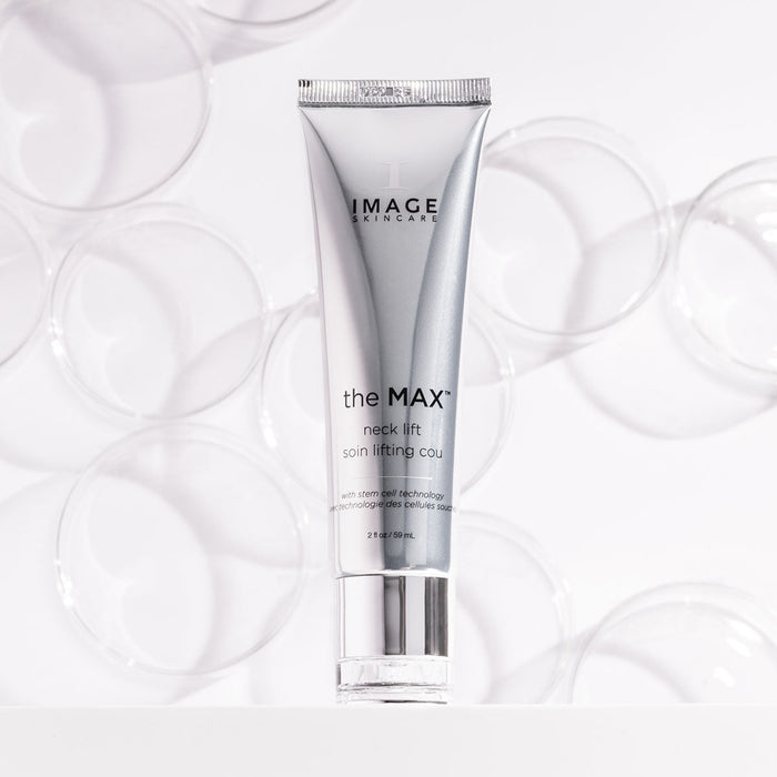 Silver tube of MAX™ neck lift | IMAGE Skincare displayed against a white background with clear circular petri dishes for a clean, clinical aesthetic