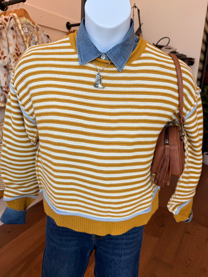 Mustard-and-white striped crew neck sweater on mannequin, ribbed collar and cuffs