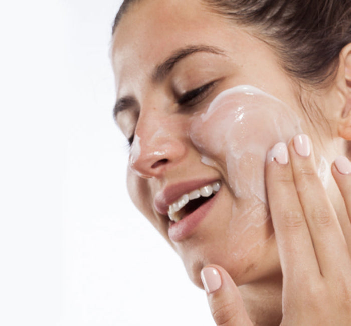 Woman applying Pudding Apeel® Tapioca + Rice Active Fruit Glycolic Mask | FarmHouse Fresh to her cheek, demonstrating skincare routine for radiant, refreshed skin.