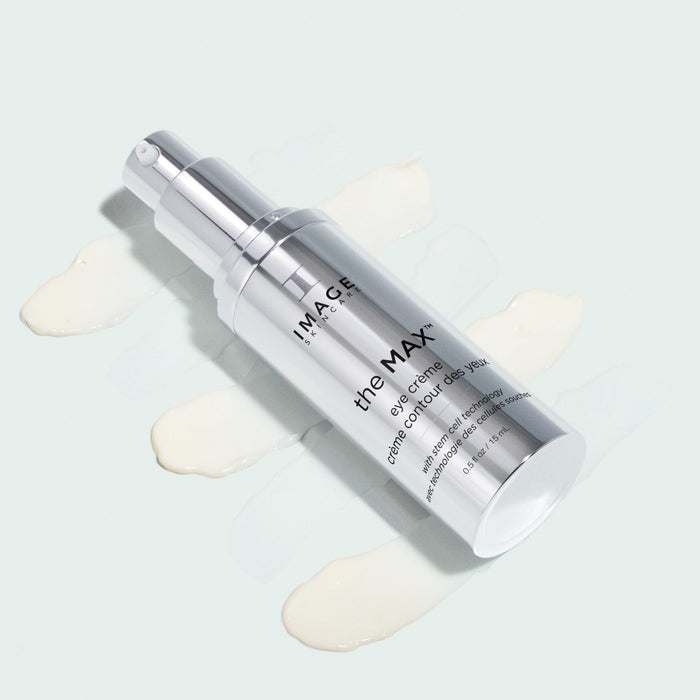 Silver pump bottle of the MAX™ eye crème | IMAGE Skincare displayed with creamy white product swatches on a light background, highlighting skincare and body care wellness.