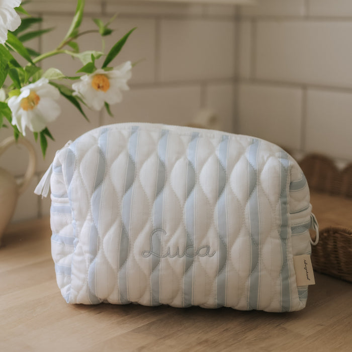 Quilted pouch with striped pattern on a wooden surface, featuring the name 'Luca'