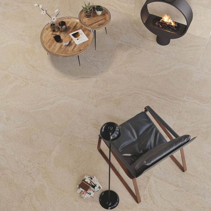 Living area with a leather chair, small round wooden coffee tables on a beige tiled floor.